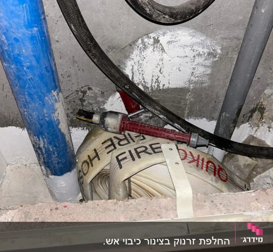 צינור כיבוי אש מגולגל עם כיתוב FIRE HOSE